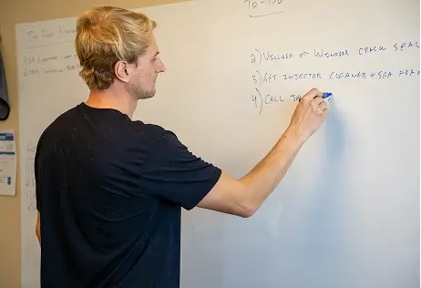 Man writing onto whiteboard Man writing onto whiteboard